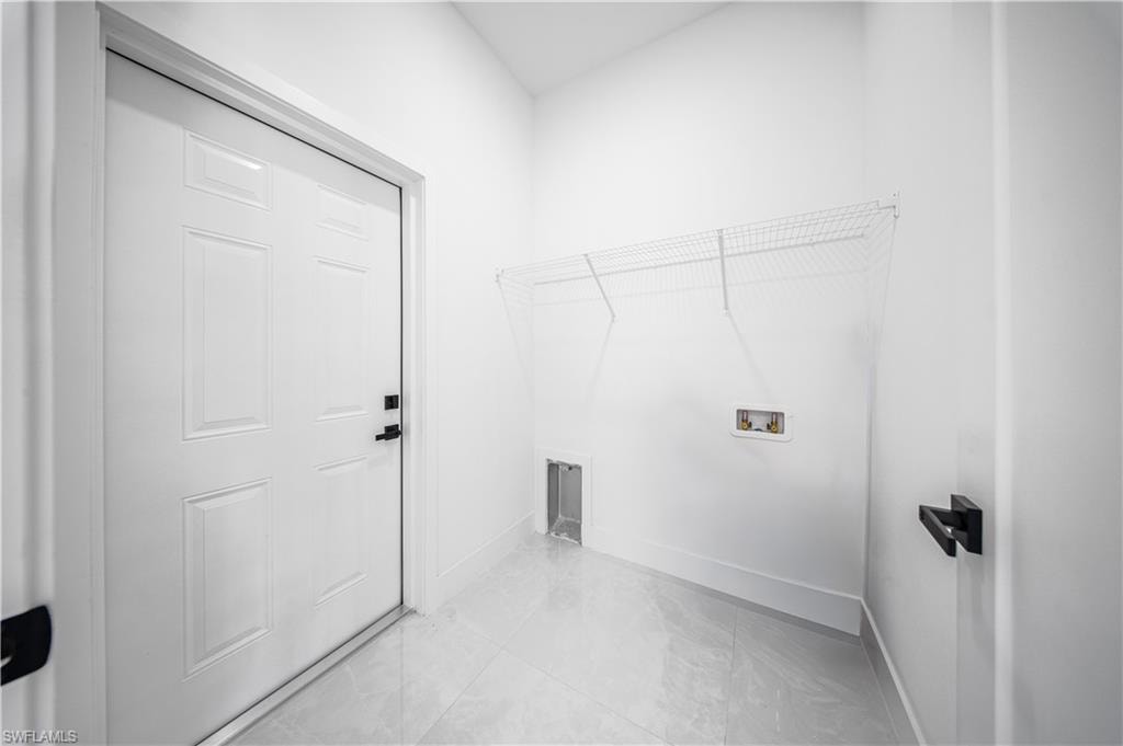 Washroom featuring light tile patterned floors and washer hookup