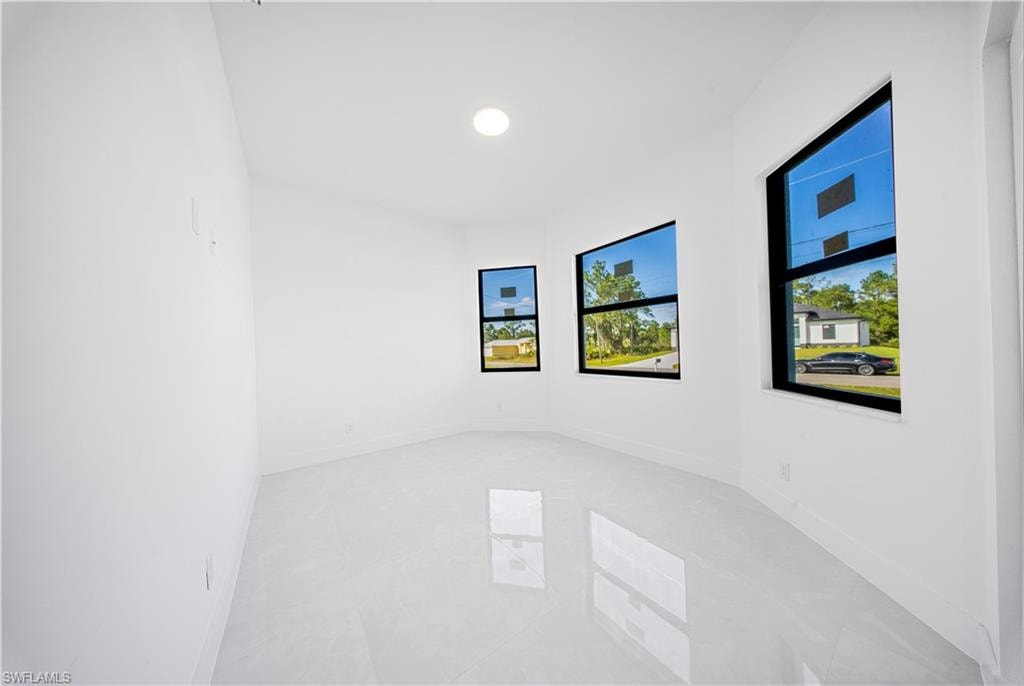 Tiled empty room featuring baseboards and recessed lighting