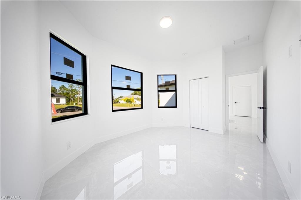 Unfurnished bedroom with multiple windows, a raised ceiling, and recessed lighting