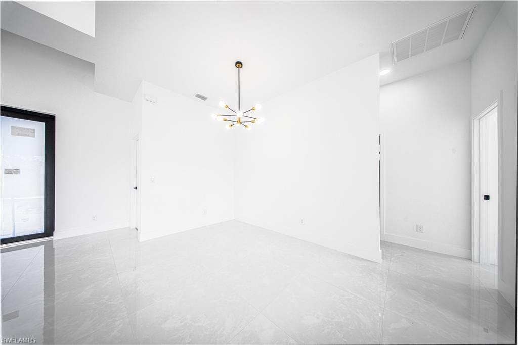 Empty room with a chandelier and baseboards