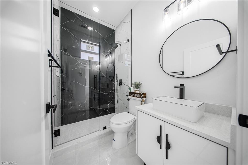 Full bathroom with vanity and a marble finish shower