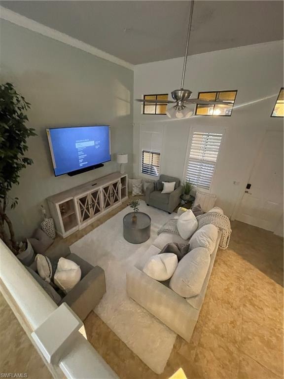 Living area featuring ceiling fan and a towering ceiling