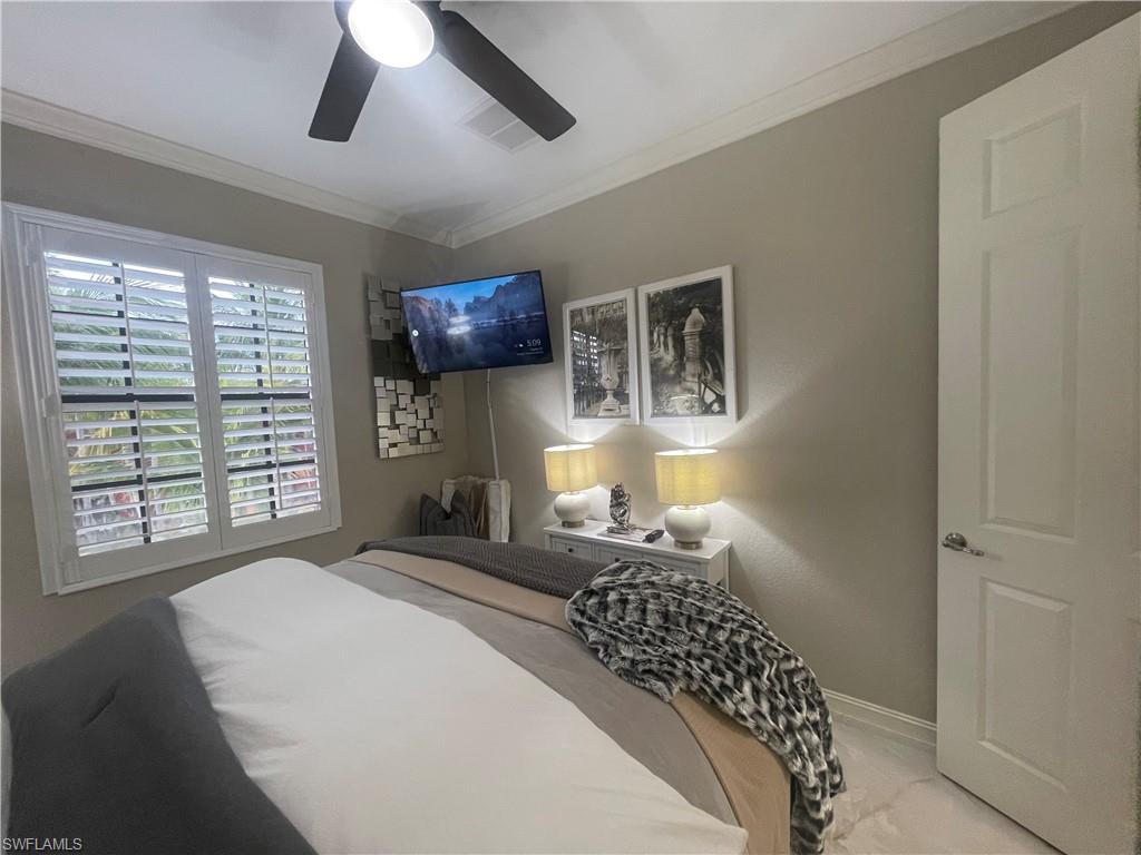 Bedroom with ornamental molding and a ceiling fan