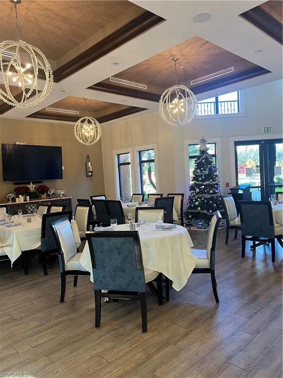 Dining room with a chandelier, hardwood / wood-style flooring, and a tray ceiling