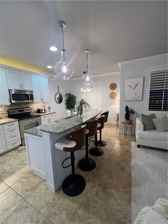 Kitchen with a breakfast bar area, range, light stone countertops, crown molding, and backsplash