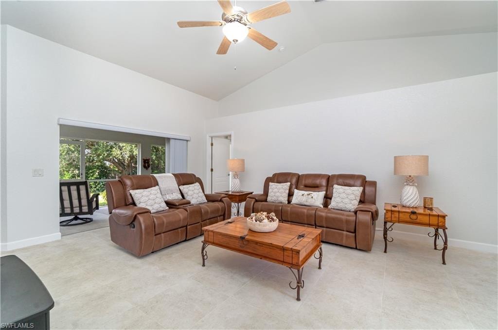 Living room with high vaulted ceiling and a ceiling fan