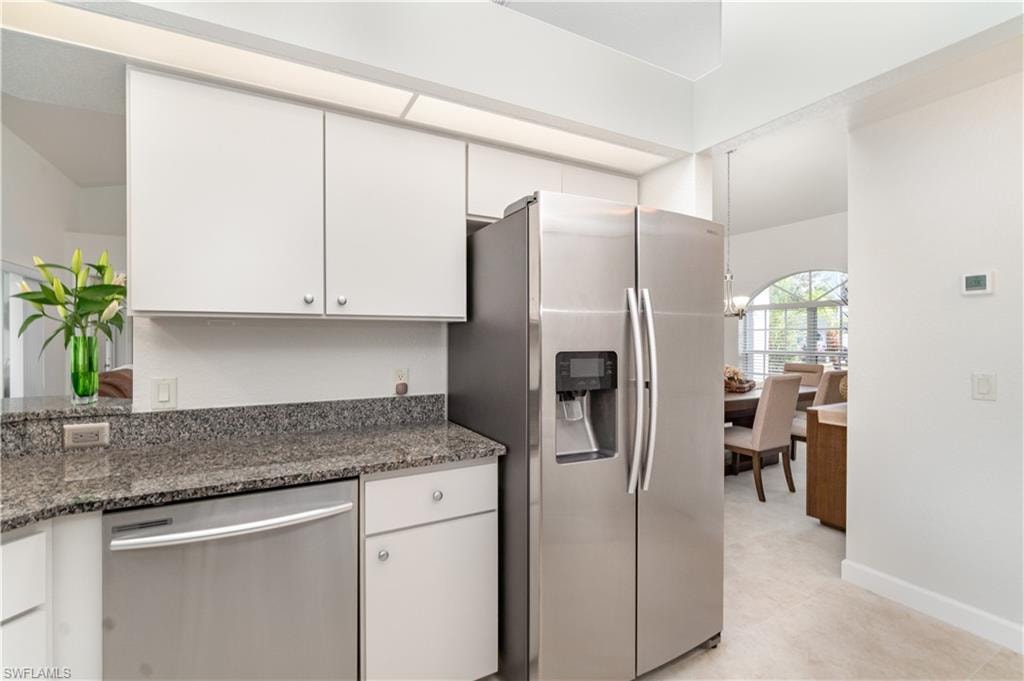 Kitchen with stainless steel appliances, dark stone countertops