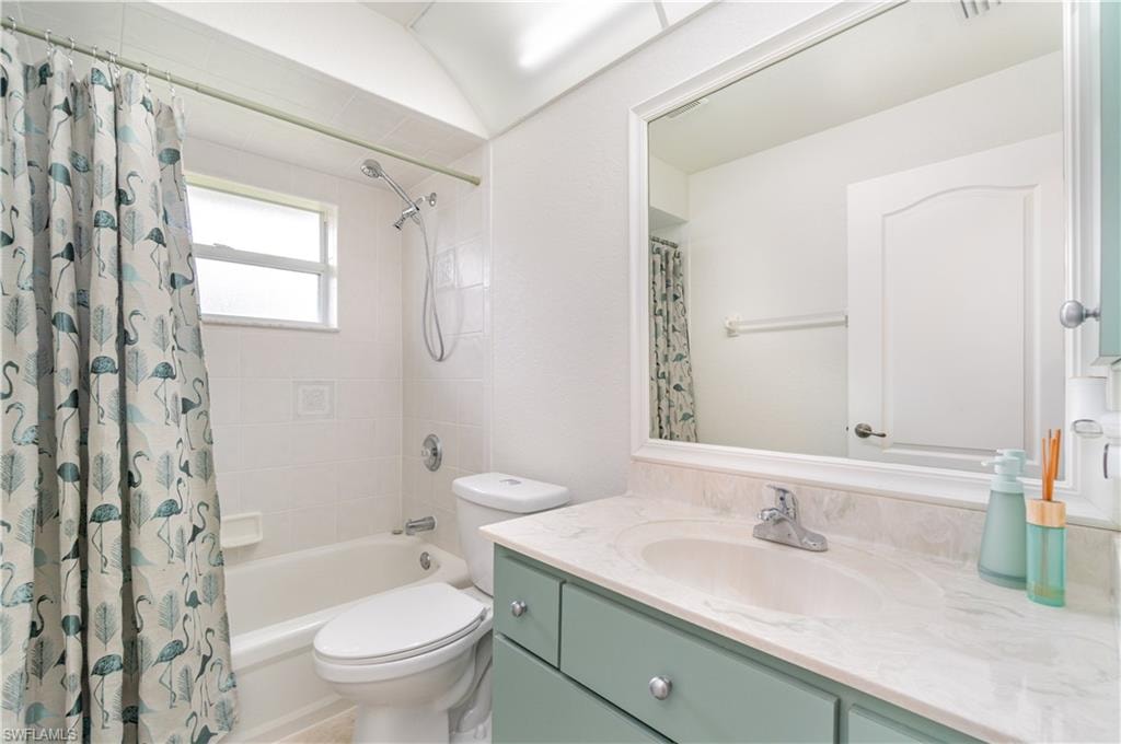 Bathroom with vanity and shower / bath combo with shower curtain