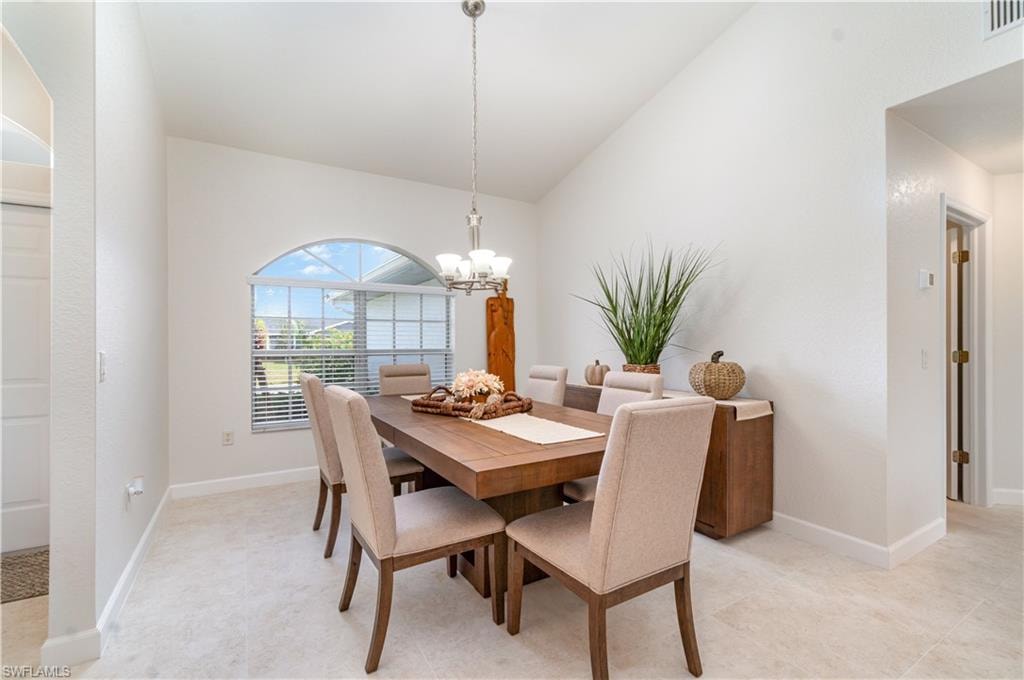 Dining room with vaulted ceiling and a chandelier