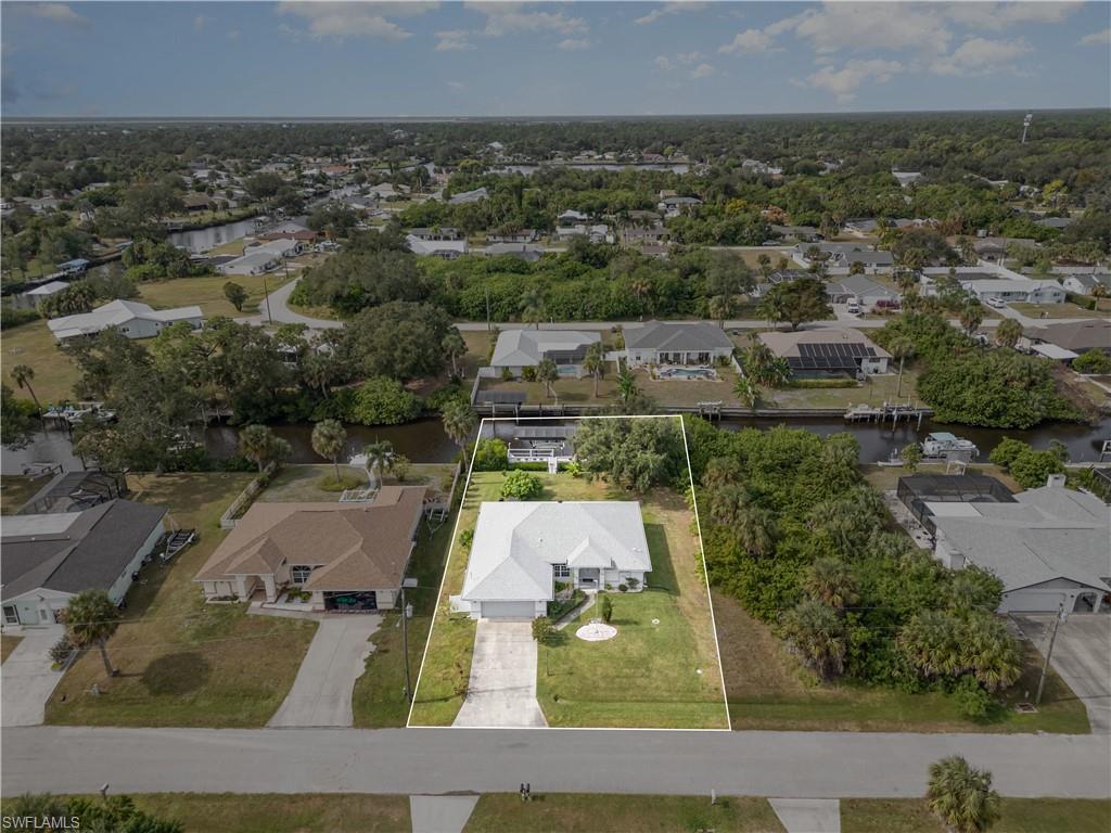 Aerial perspective of suburban area with property boundaries highlighted and a large body of water