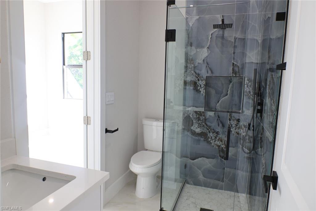 Bathroom with vanity and a marble finish shower