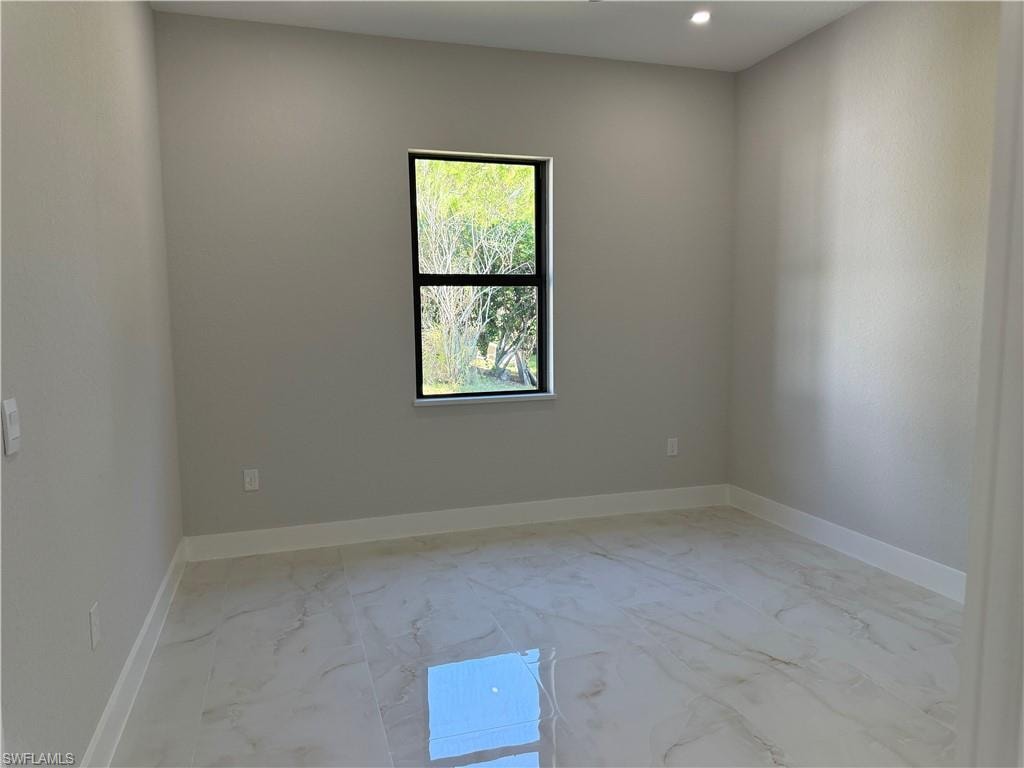 Spare room featuring light marble finish flooring and recessed lighting