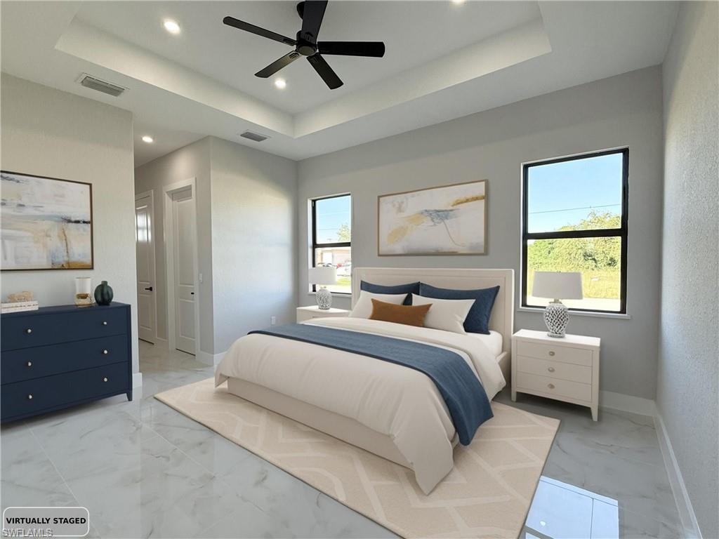 Bedroom with light marble finish floors, a ceiling fan, a tray ceiling, and recessed lighting