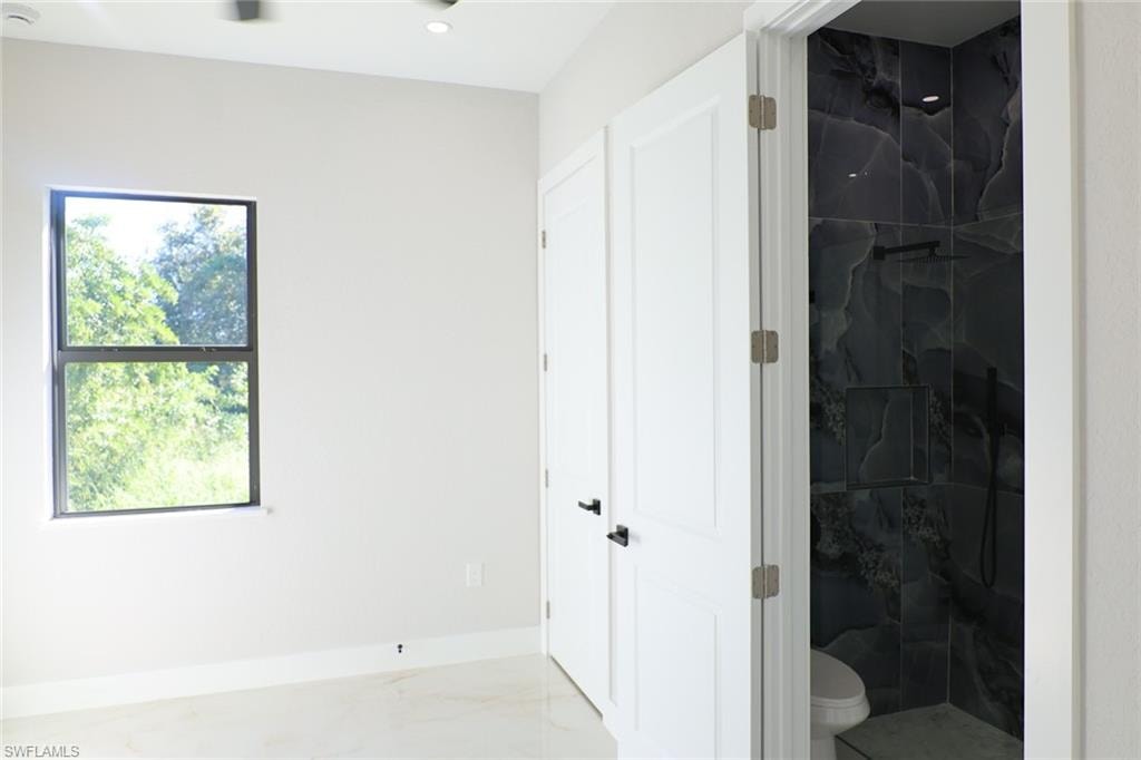 Full bath featuring a marble finish shower, marble finish flooring, and recessed lighting