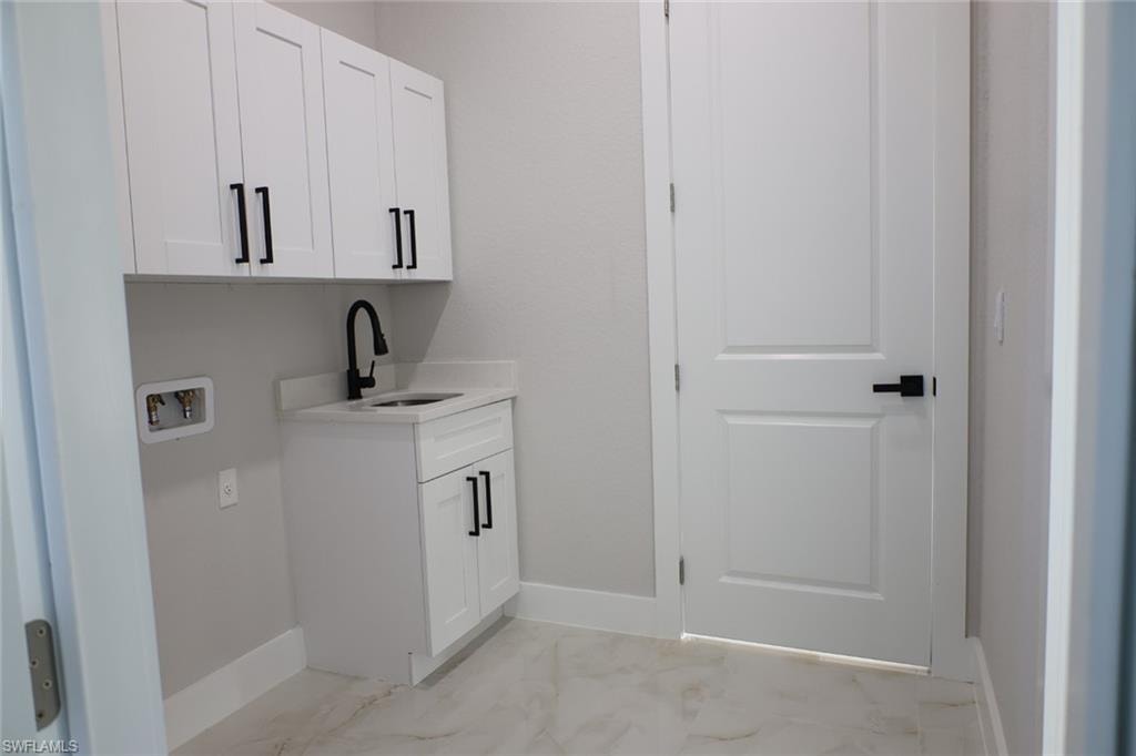 Laundry area with cabinet space and hookup for a washing machine