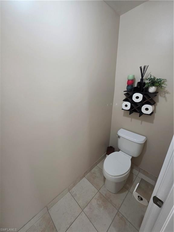 Bathroom with light tile patterned floors and toilet