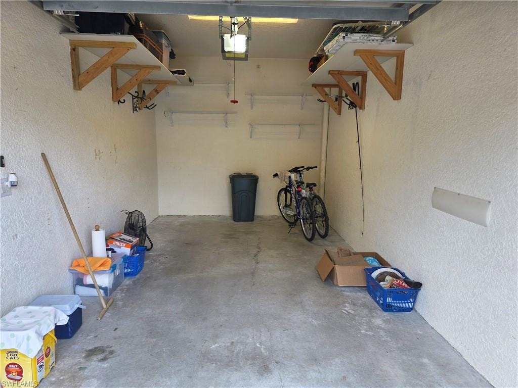 Garage featuring a textured wall and a garage door opener