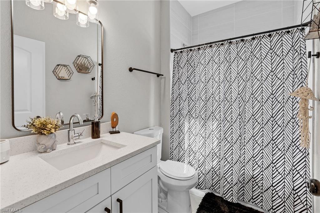 Full bath with vanity and a shower with shower curtain
