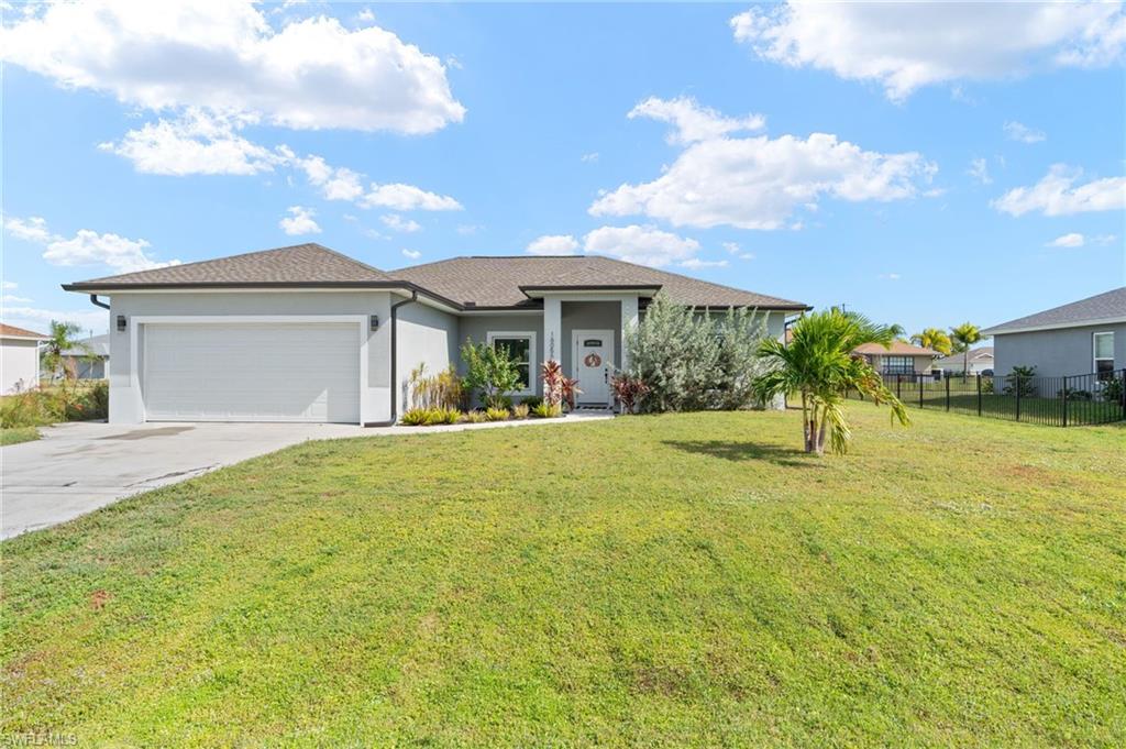 View of front facade with stucco siding, driveway, and an attached garage