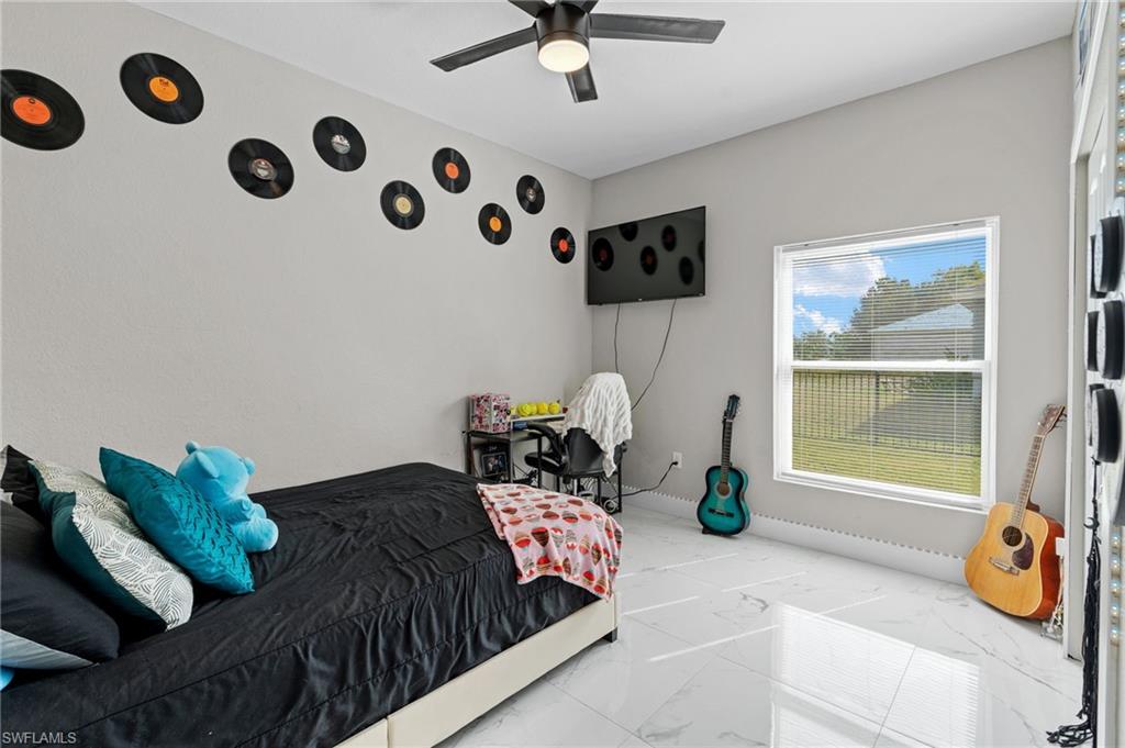 Bedroom featuring marble look tile flooring and a ceiling fan