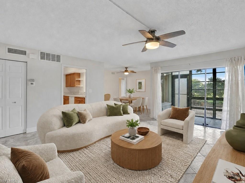 Virtual staged Living area featuring tile flooring, a ceiling fan with light fixture, and sliding glass doors to the outdoor space