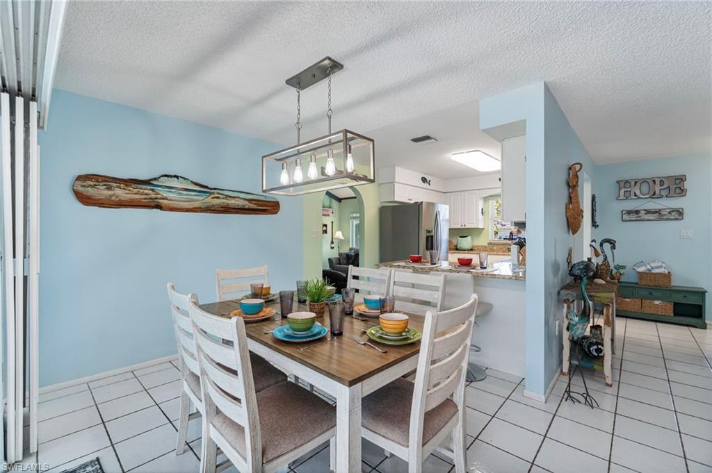 Dining area with light tile patterned floors and a textured ceiling