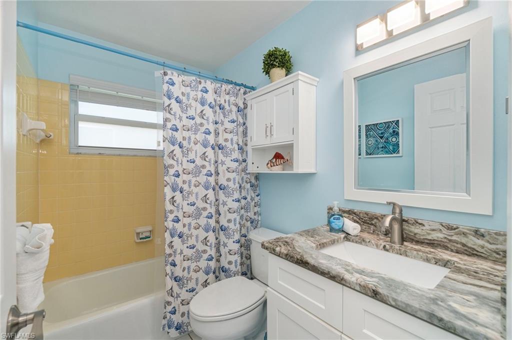 Full bath with shower / bath combo with shower curtain and vanity