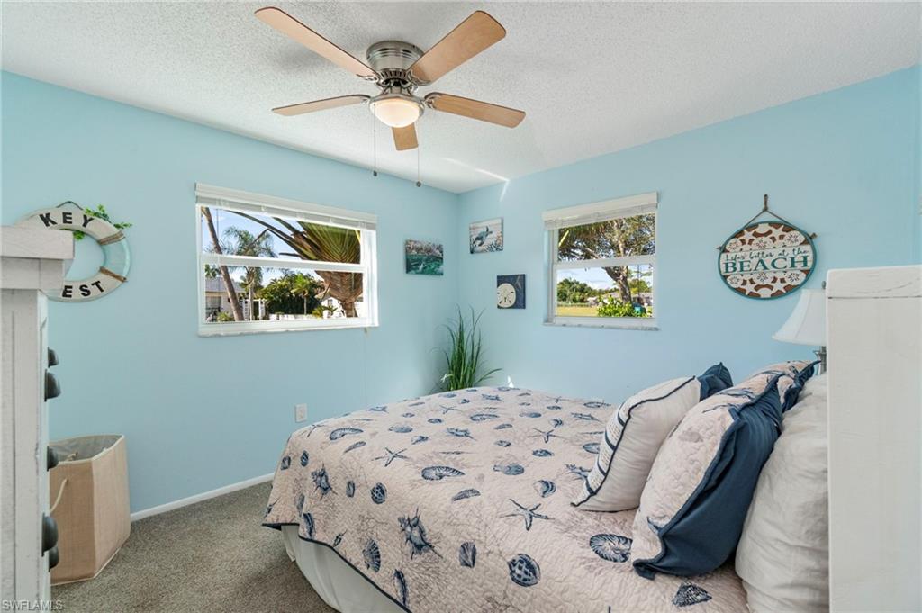 Bedroom with carpet flooring, a textured ceiling, and ceiling fan