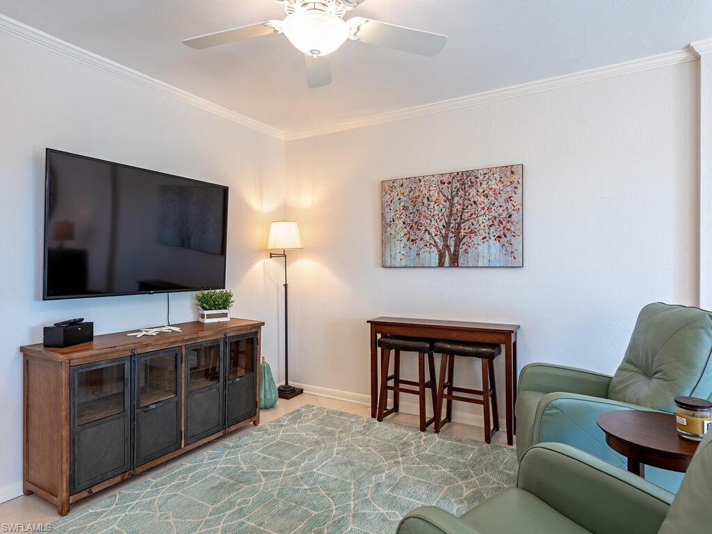 Living area featuring ornamental molding and ceiling fan