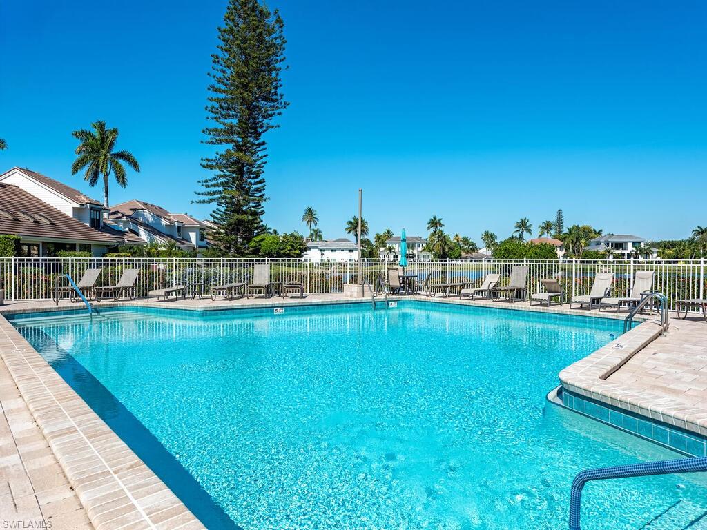 Community pool with a patio area and a residential view