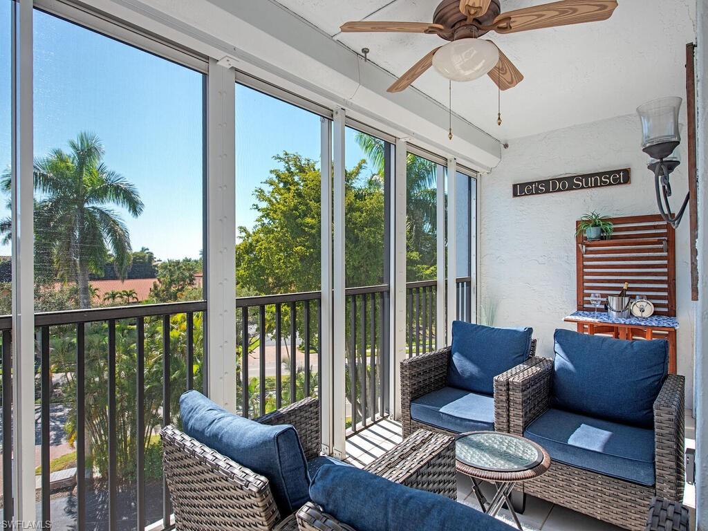 Sunroom featuring a ceiling fan and a balcony