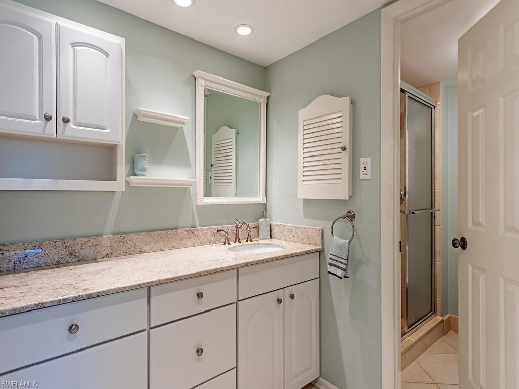 Full bath with a stall shower, light tile patterned floors, vanity, and recessed lighting
