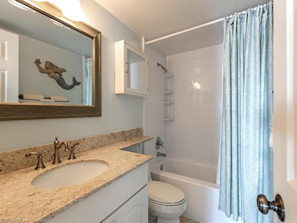 Bathroom featuring shower / bath combo with shower curtain and vanity