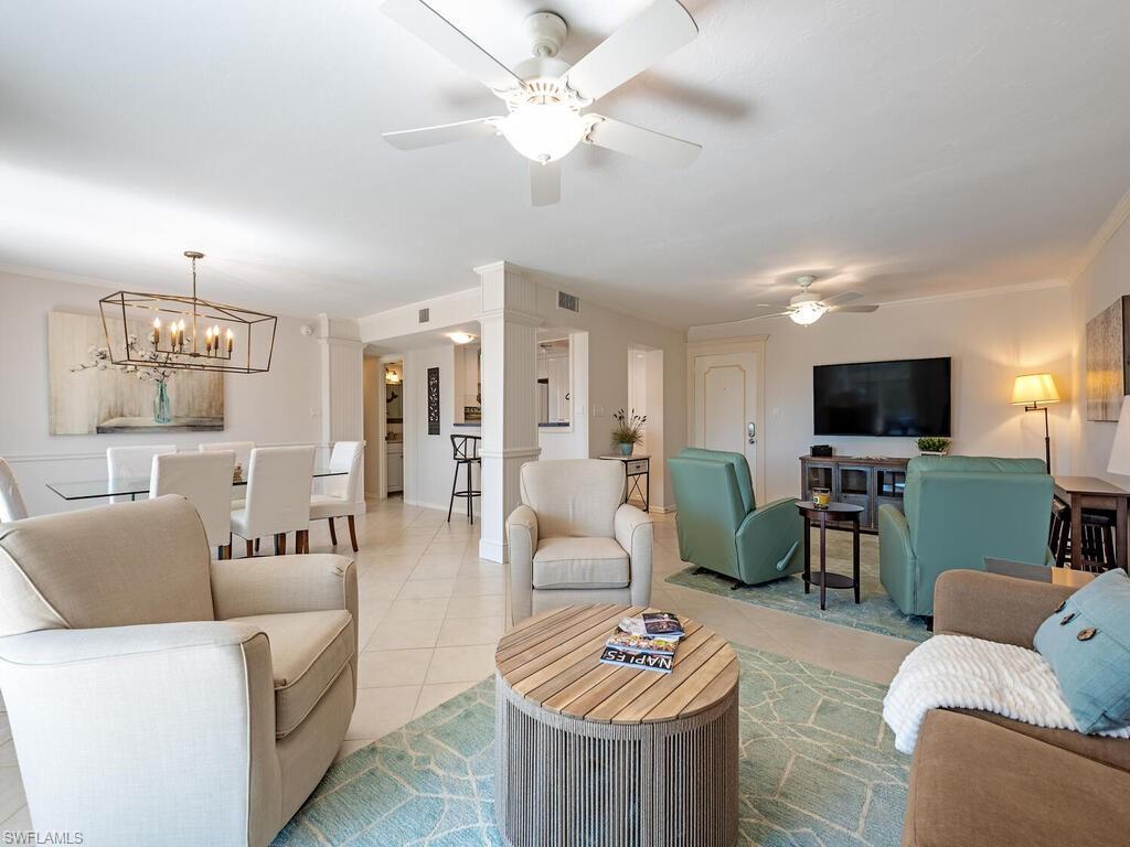 Living area with light tile patterned floors, a ceiling fan, and a chandelier