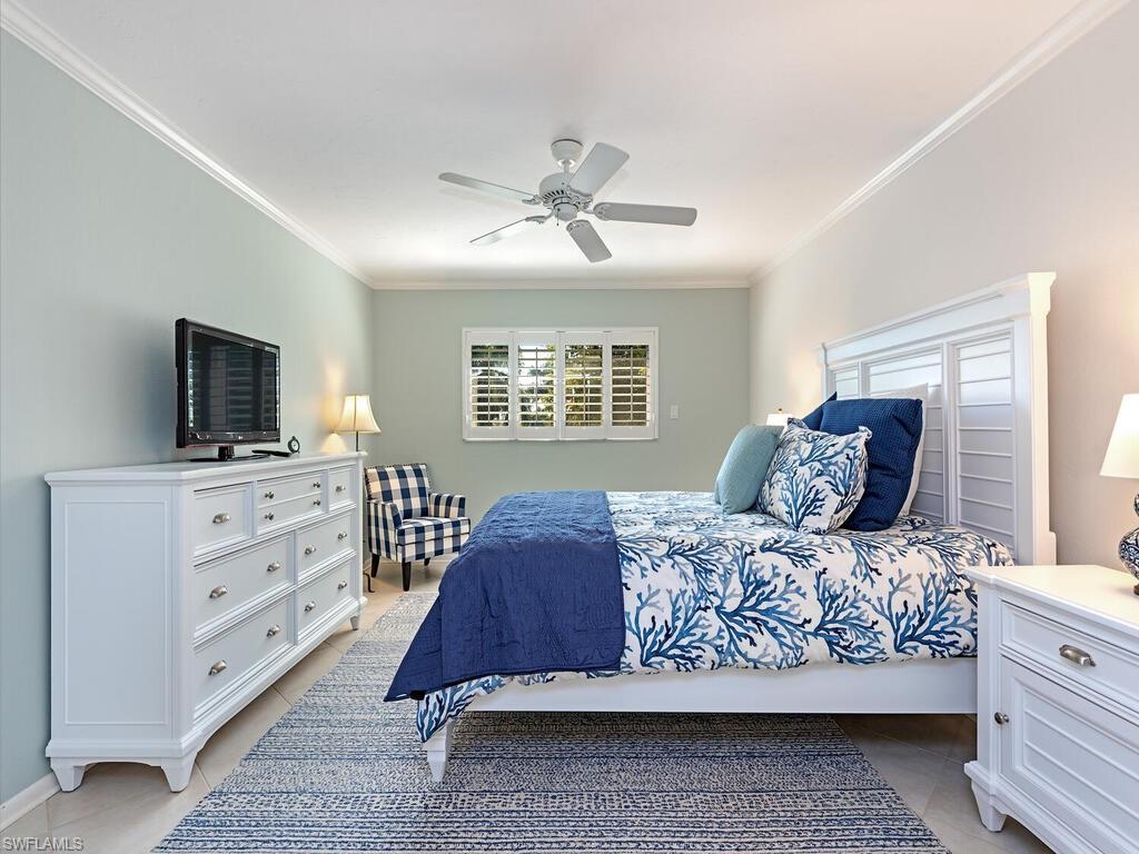 Bedroom featuring crown molding, ceiling fan, and light tile patterned floors