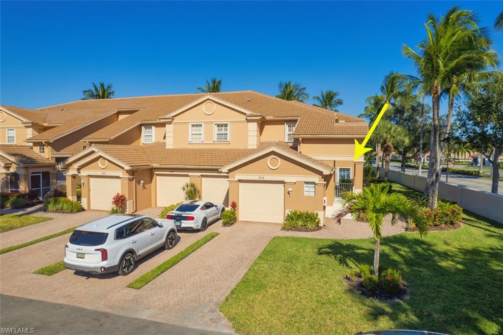 Mediterranean / spanish house featuring driveway, stucco siding, and a tile roof