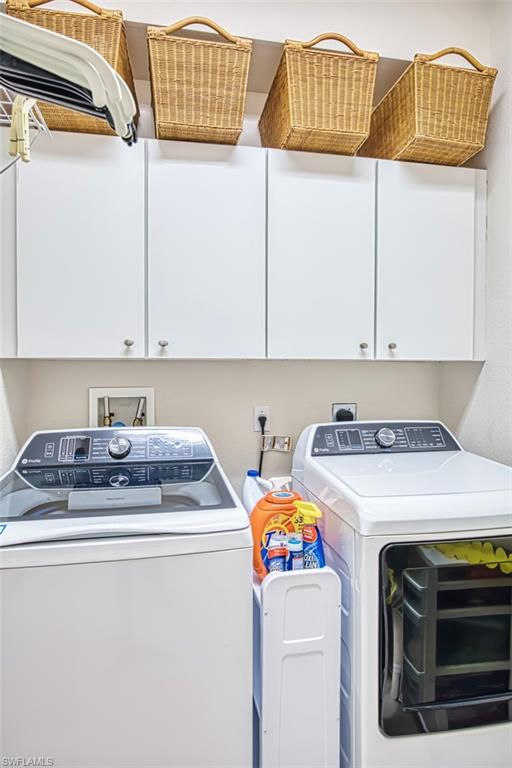 Washroom featuring washer and dryer and cabinet space