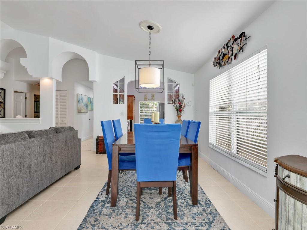 Dining room featuring light tile patterned flooring and arched walkways