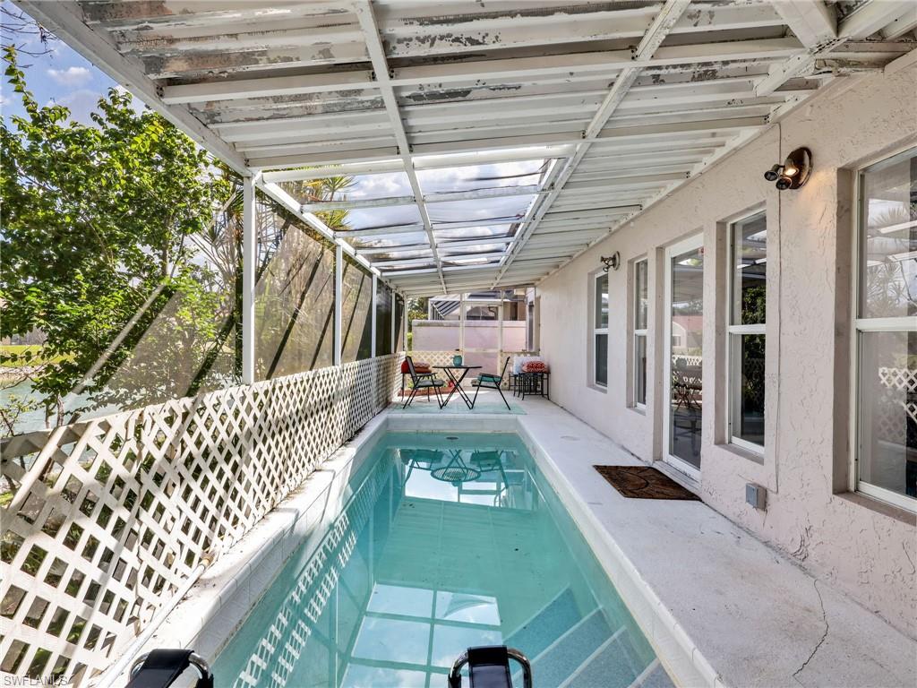 Screened patio with a covered pool, multiple windows, and a glass-paneled door