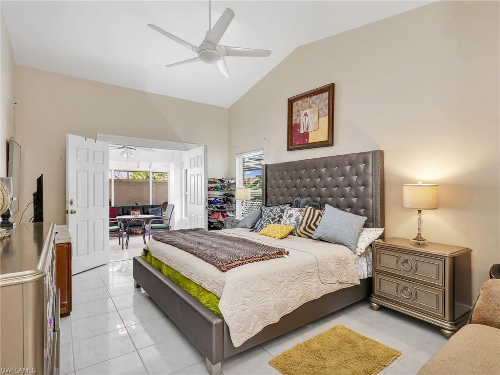 Bedroom featuring lofted ceiling, a ceiling fan, and light tile patterned flooring