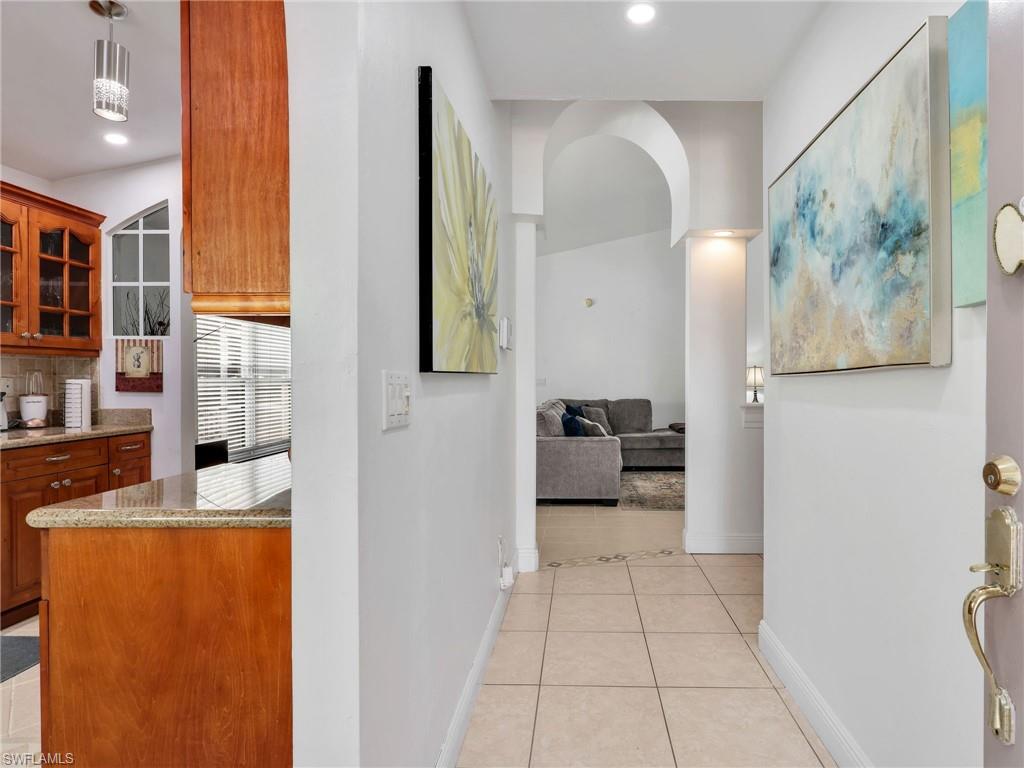 Hall with light tile patterned flooring and recessed lighting
