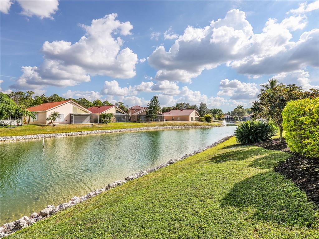 Expansive canal-front setting with a manicured lawn, established landscaping, and a rock-lined shoreline
