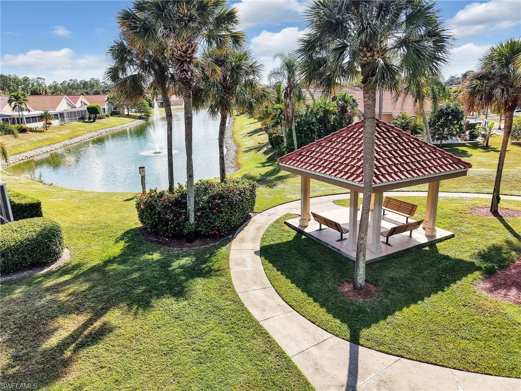 View of property's community walkway with a water view, yard, patio area with a gazebo