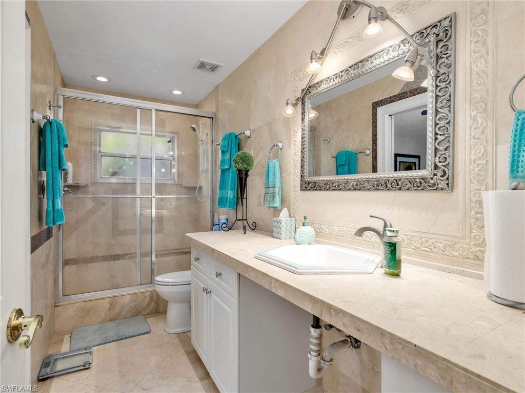 Bathroom with vanity, a shower stall, and recessed lighting
