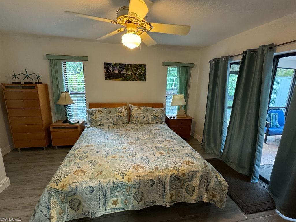 Bedroom featuring ceiling fan, multiple windows, and hardwood / wood-style floors