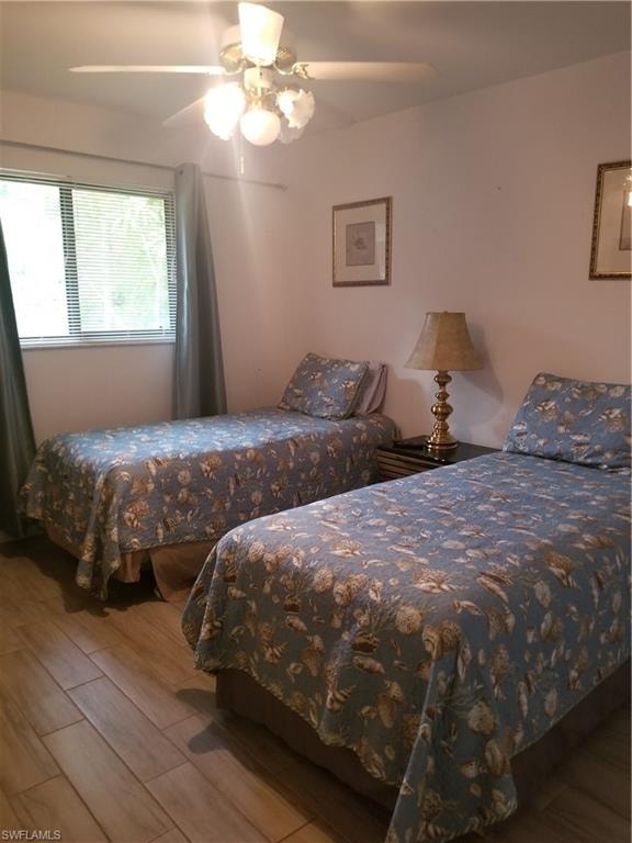 Bedroom with ceiling fan and hardwood / wood-style flooring