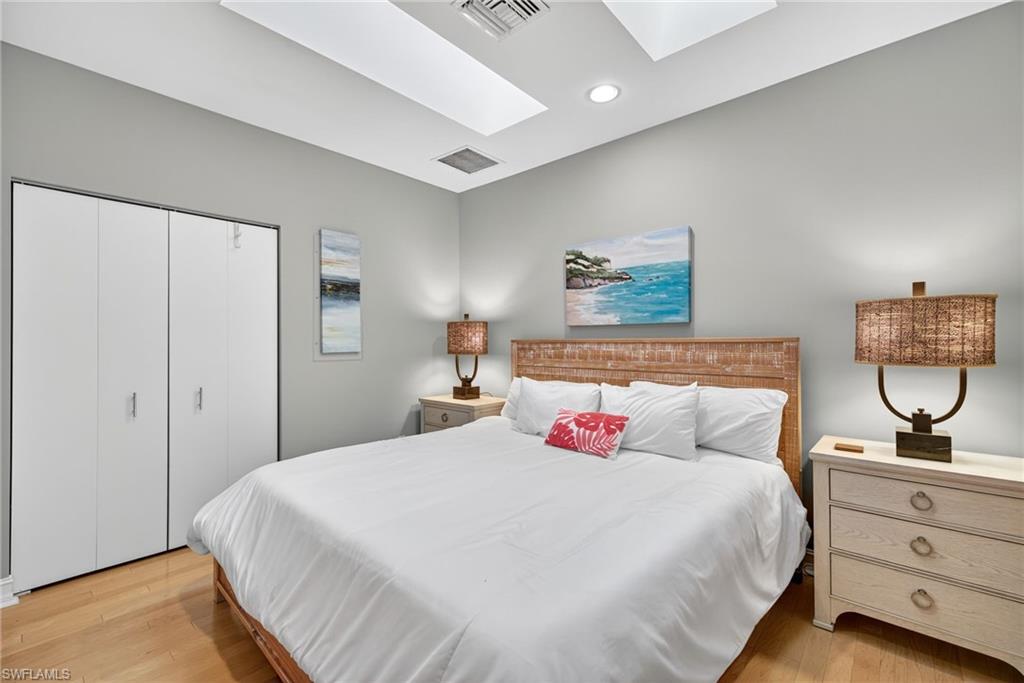 Bedroom with a skylight, light wood-style flooring, a closet, and recessed lighting