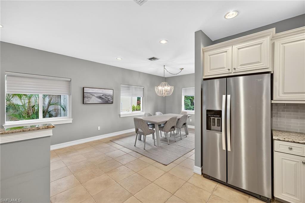 Kitchen featuring stainless steel fridge with ice dispenser, recessed lighting, light stone countertops, tasteful backsplash, and light tile patterned floors