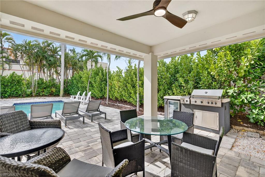 View of patio with outdoor dining area, a ceiling fan, and exterior kitchen