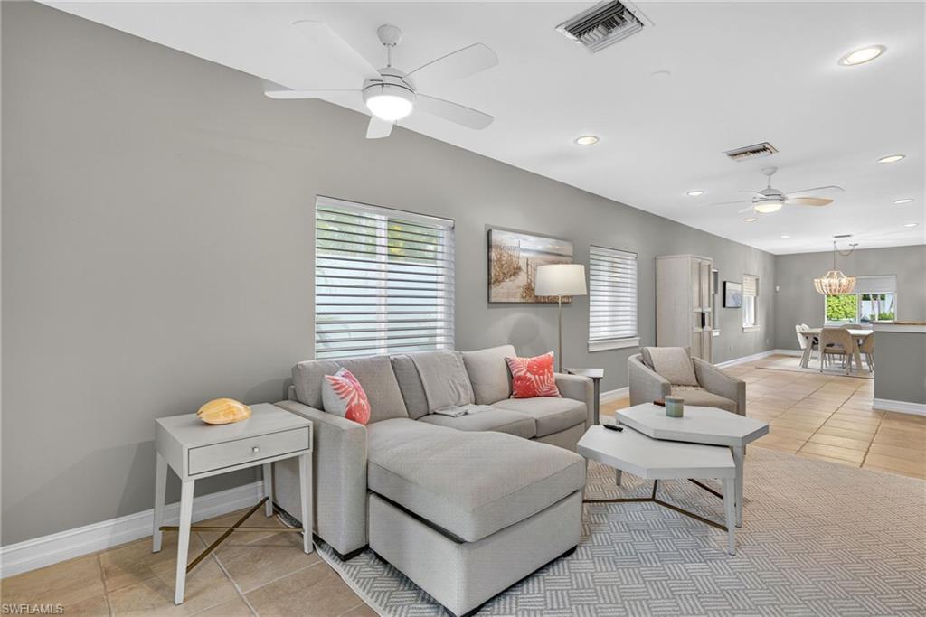Living room with light tile patterned floors, a ceiling fan, and recessed lighting